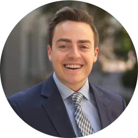 A man in suit and tie smiling for the camera.