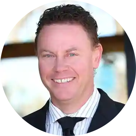 A man in suit and tie smiling for the camera.