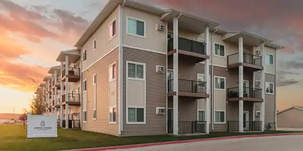 A large apartment building with balconies and railings.