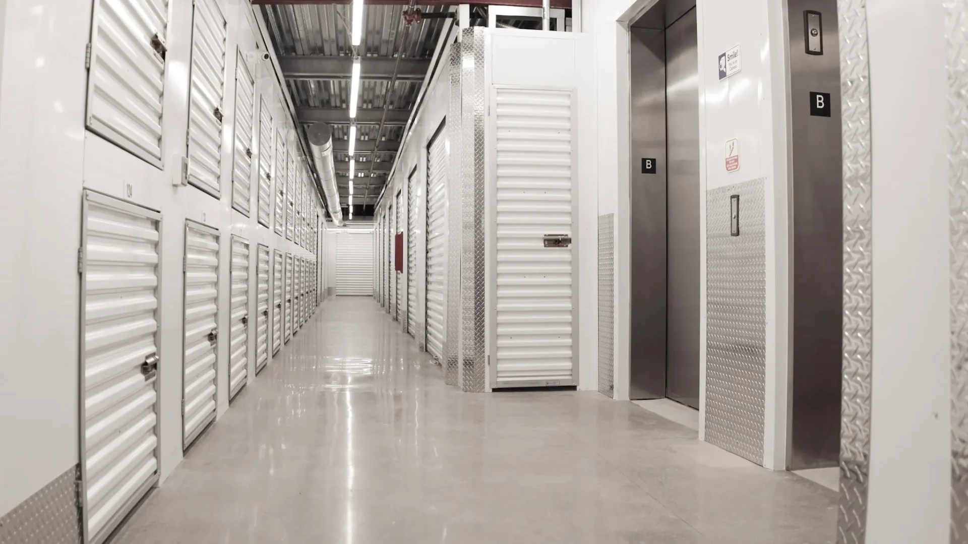 A long hallway with many storage units and doors.