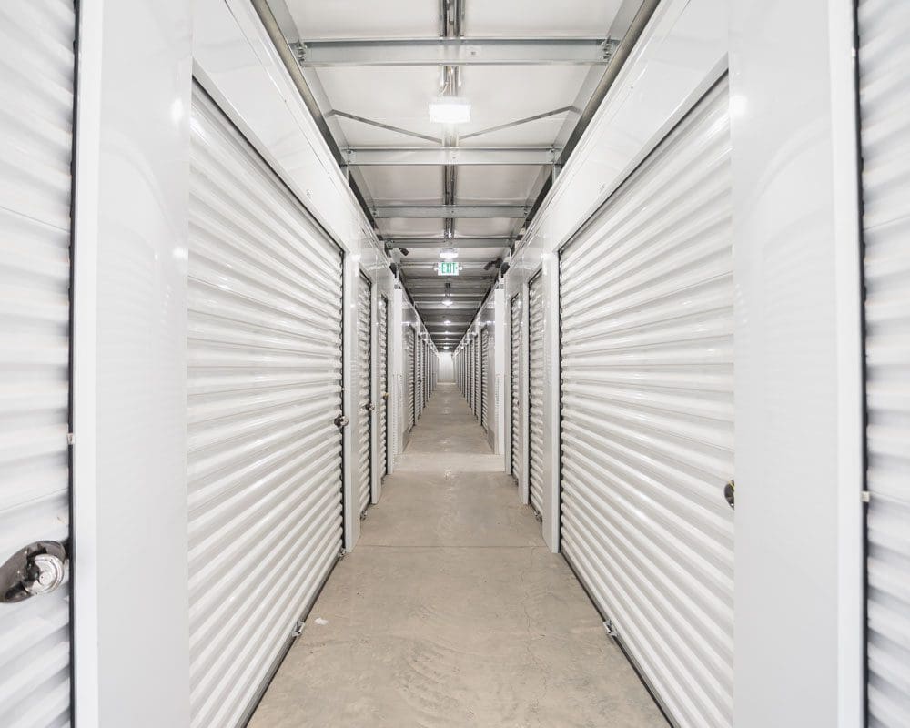 Photo of indoor hallway showing white units and clean floor at Storage 85