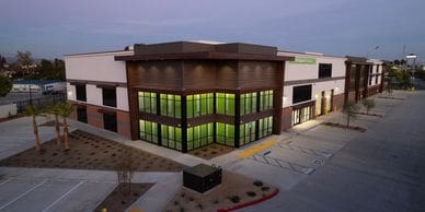 Photo of a multi-level building with glass windows with brick accents