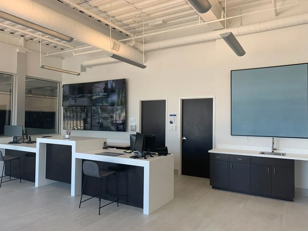 A room with two desks and a large picture on the wall.