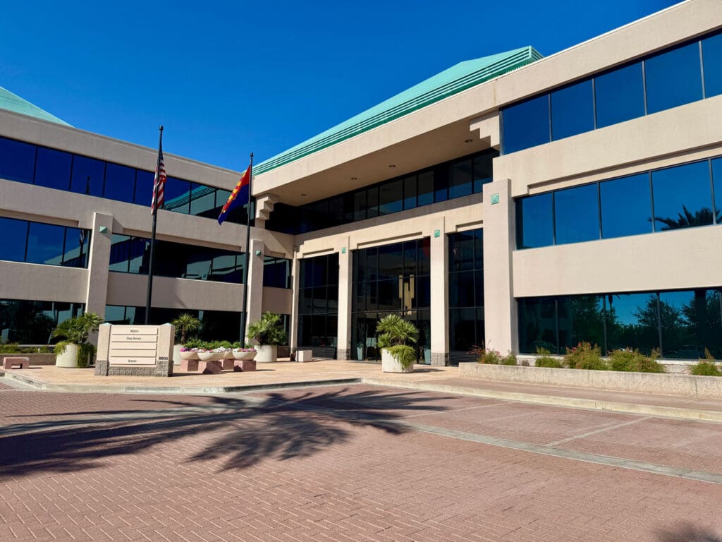 Multi-level office building with windows and bright blue sky