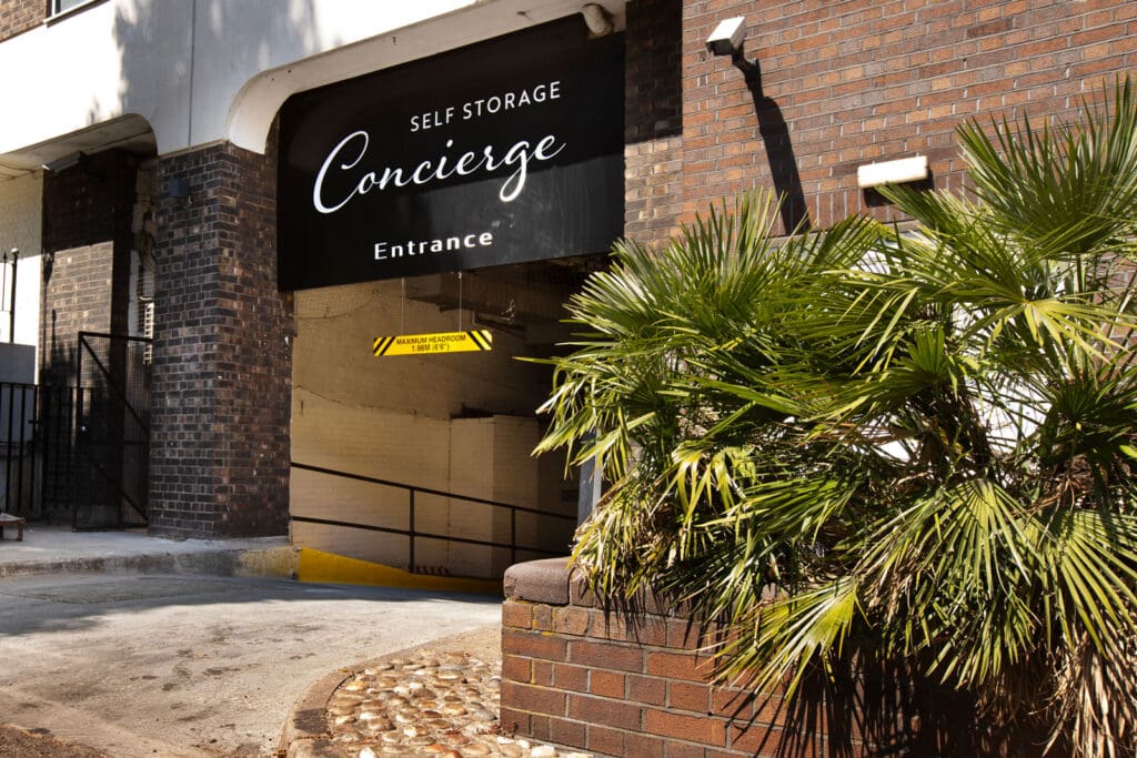 Brick building entrance with black Self Storage Concierge Signage
