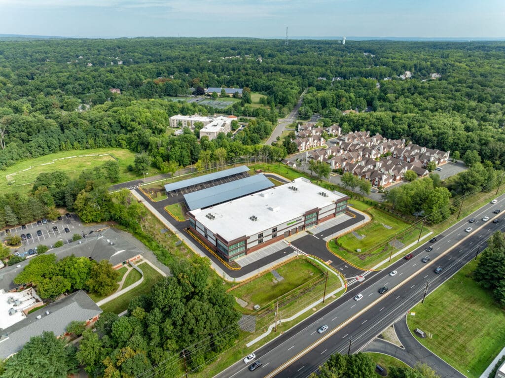 Aerial view of a multi-level storage building with brick, window, and white concrete accents