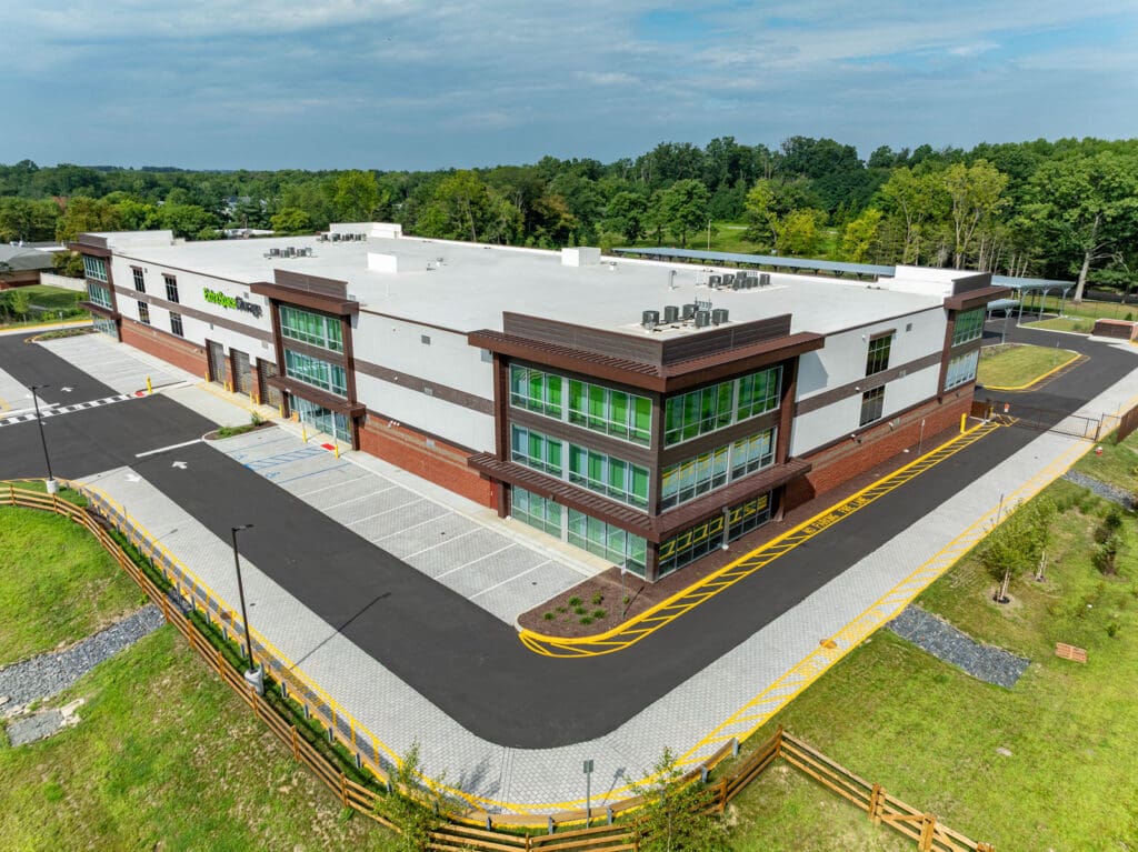 Aerial view of a multi-level storage building with brick, window, and white concrete accents