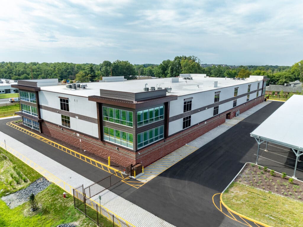 Aerial view of a multi-level storage building with brick, window, and white concrete accents