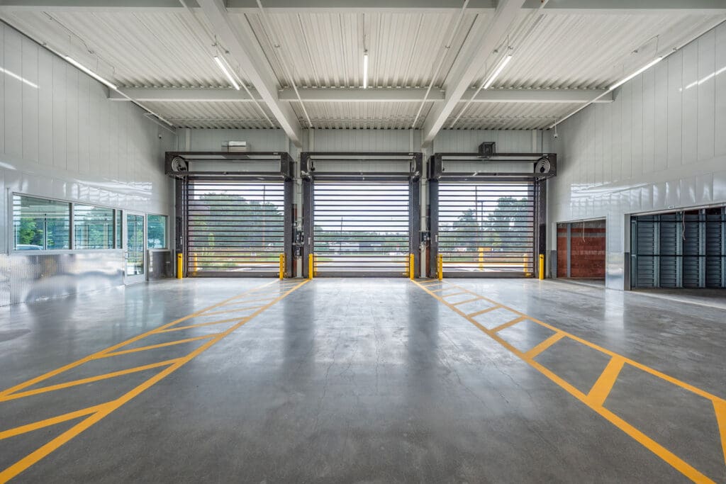 Three fast loading roll up doors in large loading bay with concrete floor